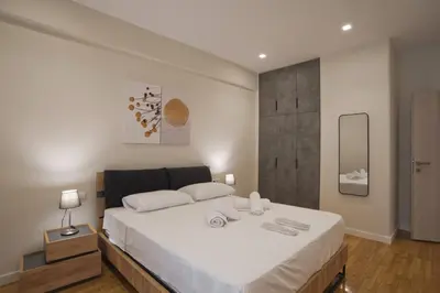 a bedroom with a large bed with white sheets at Athenian Escape 2BR, 2BA, Stylish Fully Reno Apt in Athens