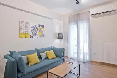 a living room with a blue couch and a table at Athenian Escape 2BR, 2BA, Stylish Fully Reno Apt in Athens