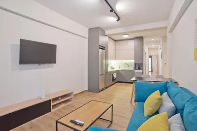 a living room with a blue couch and a tv at Athenian Escape 2BR, 2BA, Stylish Fully Reno Apt in Athens
