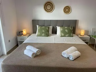 a bedroom with a large bed with towels on it at Green studio near Acropolis in Athens