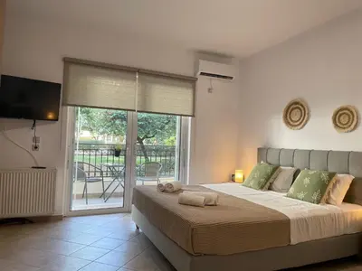a bedroom with a large bed and a balcony at Green studio near Acropolis in Athens