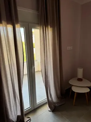 a window with curtains and a table next to a door at PUERTO VILLA, Best Location in Porto Rafti in Porto Rafti