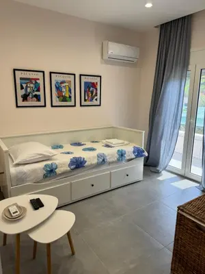 a bedroom with a bed and a table and chairs at PUERTO VILLA, Best Location in Porto Rafti in Porto Rafti