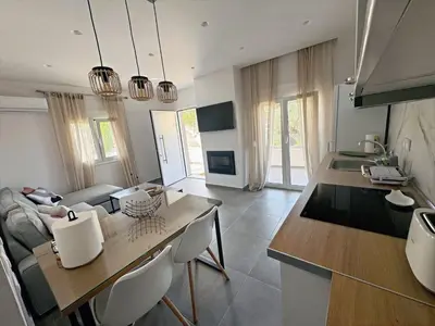 a kitchen and living room with a table and chairs at PUERTO VILLA, Best Location in Porto Rafti in Porto Rafti