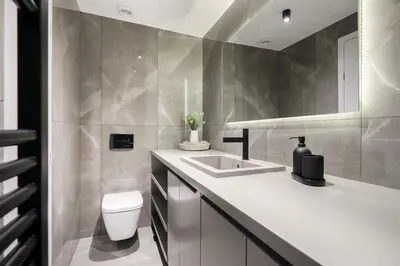 a bathroom with a white sink and a toilet at Glyfada Platinum Résidence in Athens