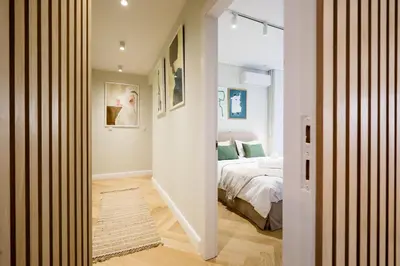 a hallway leading to a bedroom with a bed at Glyfada Platinum Résidence in Athens