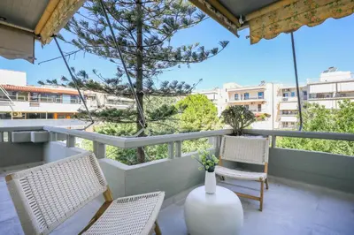 a balcony with two chairs and a table and a vase at Glyfada Platinum Résidence in Athens