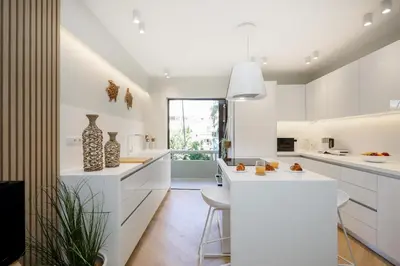 a kitchen with white cabinets and a counter with vases at Glyfada Platinum Résidence in Athens