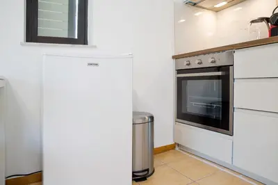 a kitchen with white cabinets and an oven at Lovely Cosy Apartment In Papagos in Athens