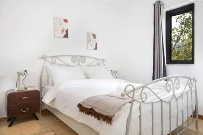 a white bedroom with a white bed and a window at Lovely Cosy Apartment In Papagos in Athens