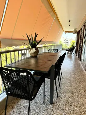 a wooden table and chairs on a balcony at R&G luxury accommodation Varkiza in Vari
