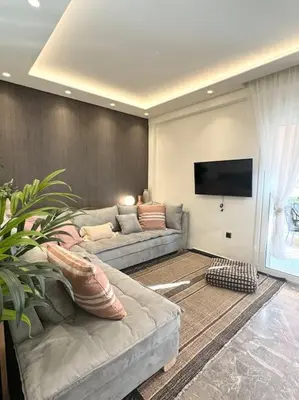 a living room with a couch and a flat screen tv at R&G luxury accommodation Varkiza in Vari