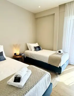 a room with two beds with towels on them at R&G luxury accommodation Varkiza in Vari