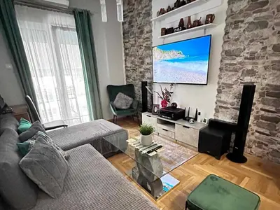 a living room with a couch and a flat screen tv at New condo Athens Kallimarmaro in Athens