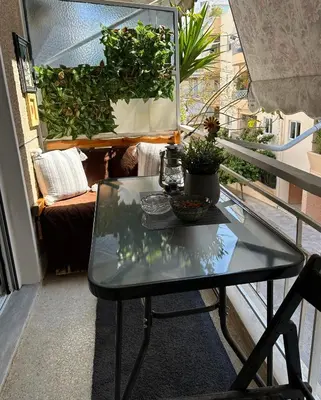 a black table on a balcony with plants at New condo Athens Kallimarmaro in Athens