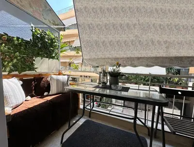 a living room with a couch and a glass table at New condo Athens Kallimarmaro in Athens