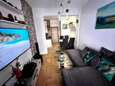a living room with a large flat screen tv on a wall at New condo Athens Kallimarmaro in Athens
