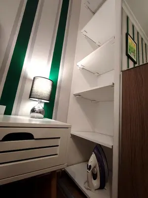 a closet with a desk with a lamp and a roll of toilet paper at New condo Athens Kallimarmaro in Athens