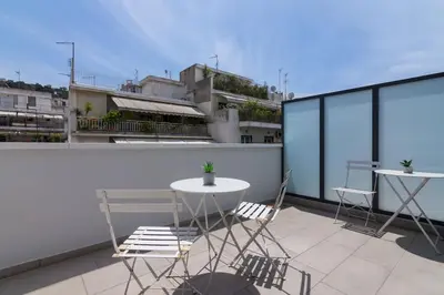 a patio with two chairs and a table on a balcony at Athens Trikoupi Suite E2 in Athens