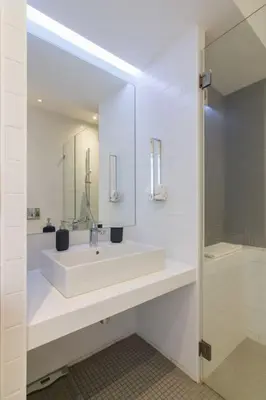 a white bathroom with a sink and a mirror at Athens Trikoupi Suite E2 in Athens