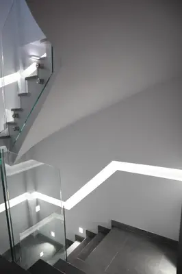 a staircase with white walls and a glass railing at Golden Sand Suites in Anavissos