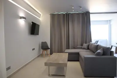 a living room with a couch and a table at Golden Sand Suites in Anavissos