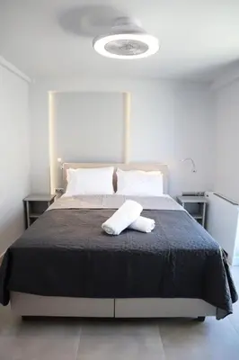 a bedroom with a large bed with a black blanket at Golden Sand Suites 2 in Anavissos