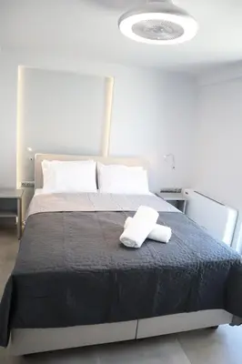 a bedroom with a bed with two towels on it at Golden Sand Suites 2 in Anavissos