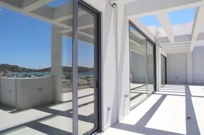 a view from the balcony of a house with glass doors at Golden Sand Suites 2 in Anavissos