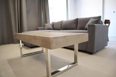 a wooden table in a living room with a couch at Golden Sand Suites 2 in Anavissos