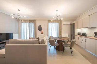 a kitchen and living room with a table and chairs at Chic 2BR Apartment with Balcony in Athens