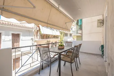 a dining room with a table and chairs on a balcony at Chic 2BR Apartment with Balcony in Athens