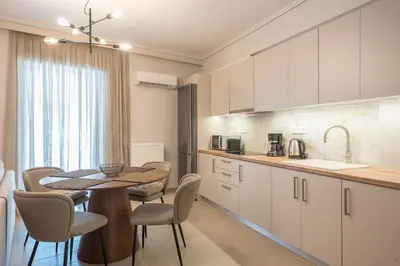 a kitchen and dining room with a table and chairs at Chic 2BR Apartment with Balcony in Athens