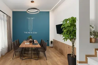 a dining room with a blue wall and a table and chairs at The Meta Stay - Rooftop Access 1 bedroom suite in Athens
