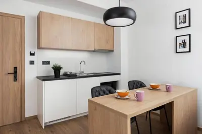 a kitchen with a wooden table with chairs and a sink at The Meta Stay - Rooftop Access 1 bedroom suite in Athens