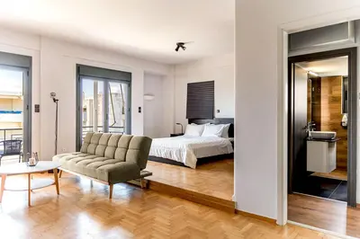 a bedroom with a bed and a couch at Boutique39 Luxury Apartment Glyfada Athens in Athens