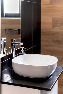 a white sink on a black counter in a bathroom at Boutique39 Luxury Apartment Glyfada Athens in Athens
