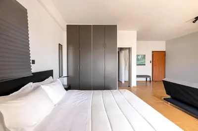 a bedroom with a large white bed with a black headboard at Boutique39 Luxury Apartment Glyfada Athens in Athens