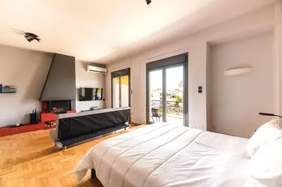 a bedroom with a large bed and a fireplace at Boutique39 Luxury Apartment Glyfada Athens in Athens