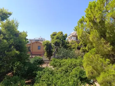 a view of a house through the trees at Beach of Voula in Athens