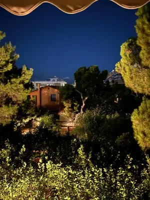 a house in the middle of a forest of trees at Beach of Voula in Athens