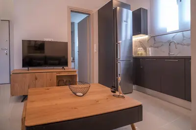 a kitchen with a wooden table and a refrigerator at Katia Athens Apartment in Athens
