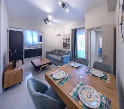 a living room with a table and chairs and a couch at Katia Athens Apartment in Athens
