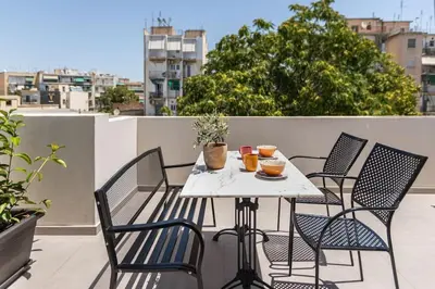 a white table and chairs on a balcony at The Meta Stay - Rooftop Access Unique Suite in Athens