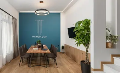 a dining room with a table and chairs and a blue wall at The Meta Stay - Rooftop Access Unique Suite in Athens