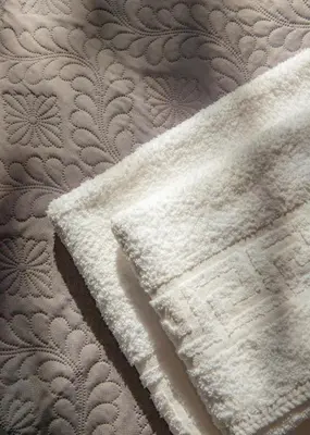 a close up of a white blanket on a bed at The Meta Stay - Rooftop Access Unique Suite in Athens
