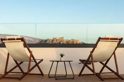 two chairs and a table in front of a window at The Meta Stay - Rooftop Access Unique Suite in Athens