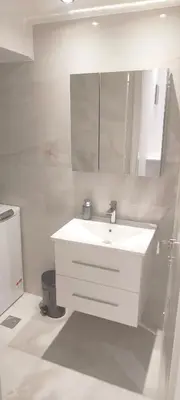 a white bathroom with a sink and a mirror at Alema Apartment in Athens