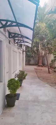 a patio with potted plants and a blue roof at Alema Apartment in Athens