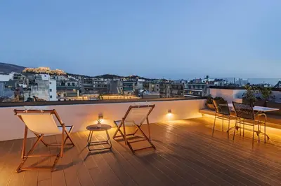 a group of chairs and a table on a balcony at The Meta Stay - Rooftop Access Unique Penthouse in Athens